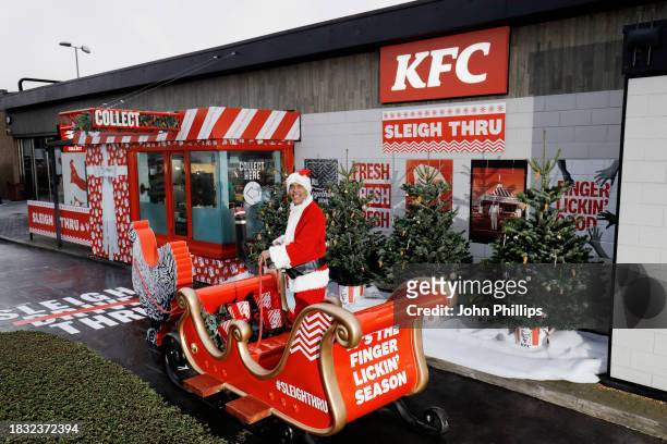 In this image released on December 11 Chris Kamara visits a KFC's Sleigh Thru to launch the Stuffing Stacker Burger in Slough,England. To celebrate...