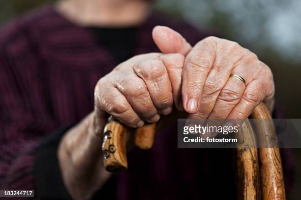 close-up of senior woman's hands holding her walking sticks - grandma cane stock pictures, royalty-free photos & images