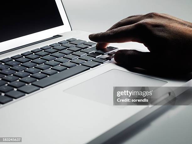 man's hand on a laptop keyboard, pressing the enter key. - touchpad bildbanksfoton och bilder