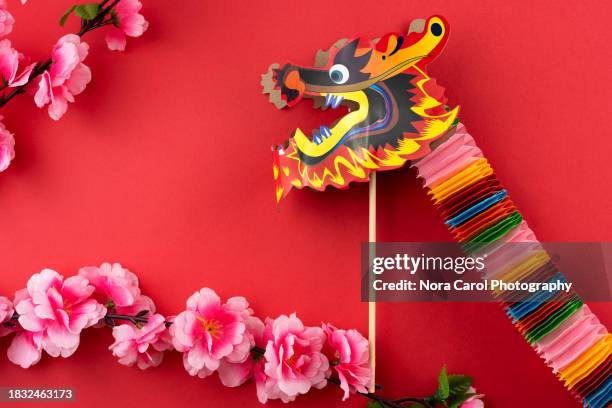 origami dragon and cherry blossom on red background - chinesisches-sternzeichen stock-fotos und bilder