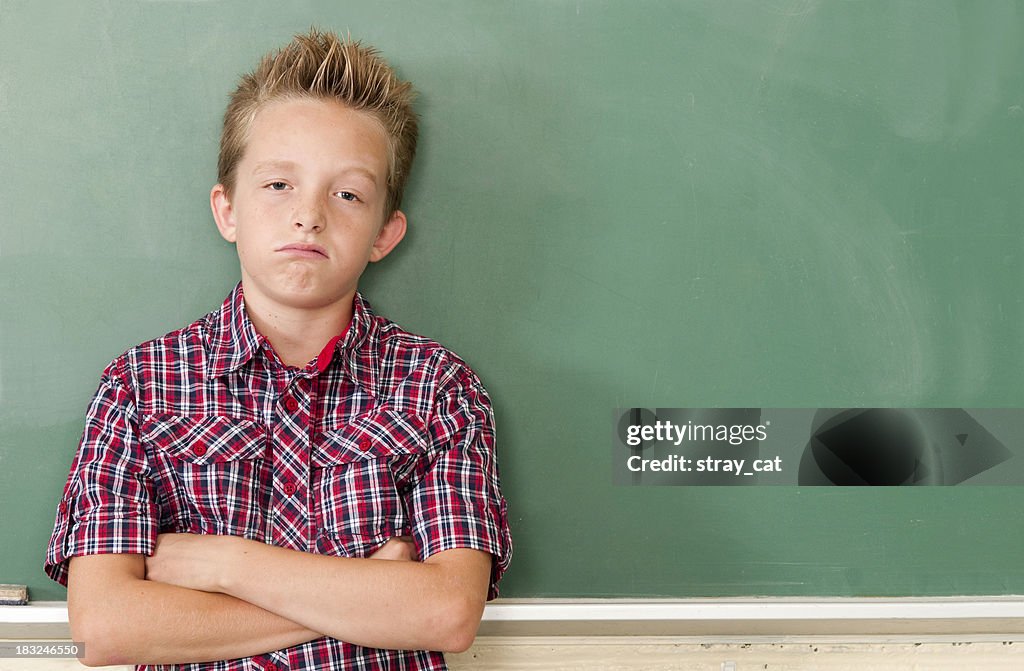 School Days: Bored Kid at Chalkboard with Copyspace