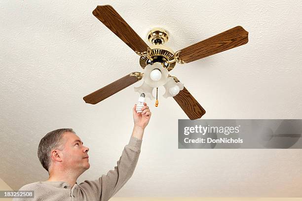 man changing light bulbs - installing ceiling light fixture stock pictures, royalty-free photos & images