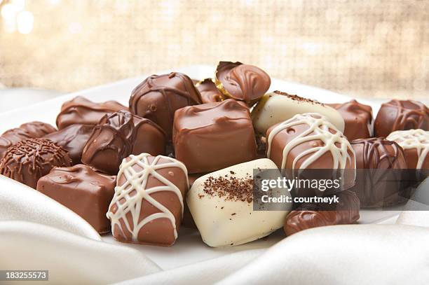 chocolate collection on a silk ackground - bonbons stockfoto's en -beelden