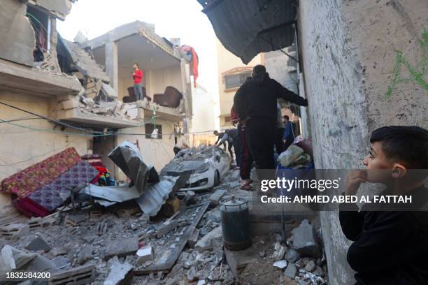 Young boy looks on as Palestinians check the damage following Israeli bombardment on Khan Yunis in the southern Gaza Strip on December 8 amid...