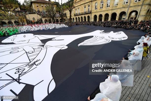 People create a human mosaic representing the Palestinian flag and hold a canvas with a detail of Pablo Picasso's masterpiece "Gernica" , that...