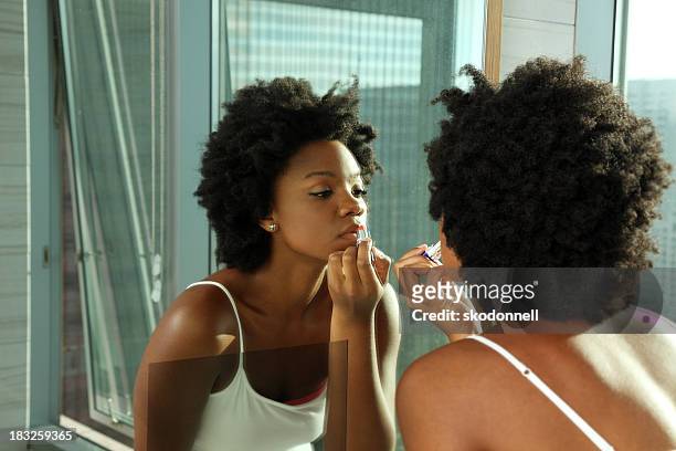 afro-americana donna mettendo il rossetto su uno specchio - rossetto foto e immagini stock