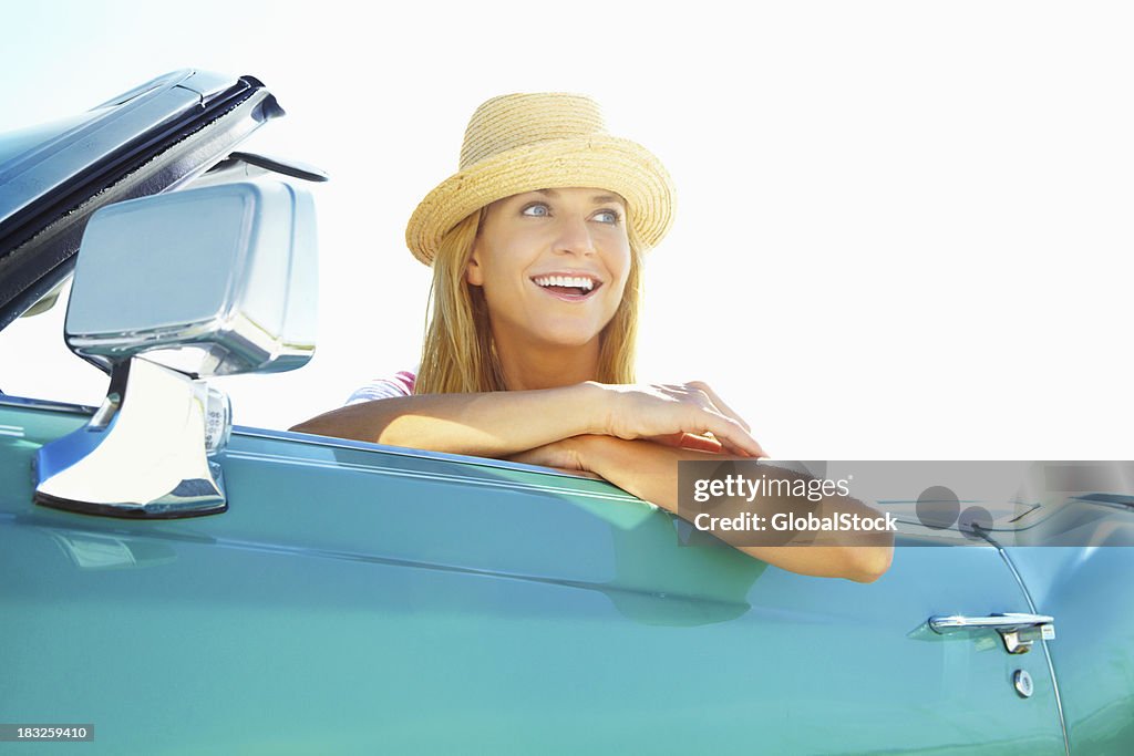 Lächelnde Junge Frau mit Hut in einem Cabrio Auto