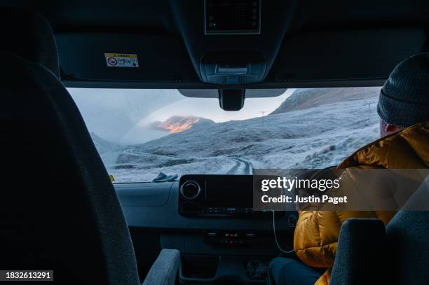 rear view of a man driving his campervan on a single track road in the scottish highlands on a cold frosty day - blue jacket stock pictures, royalty-free photos & images