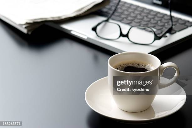 laptop and a cup of coffee on office desk - black cup saucer stock pictures, royalty-free photos & images