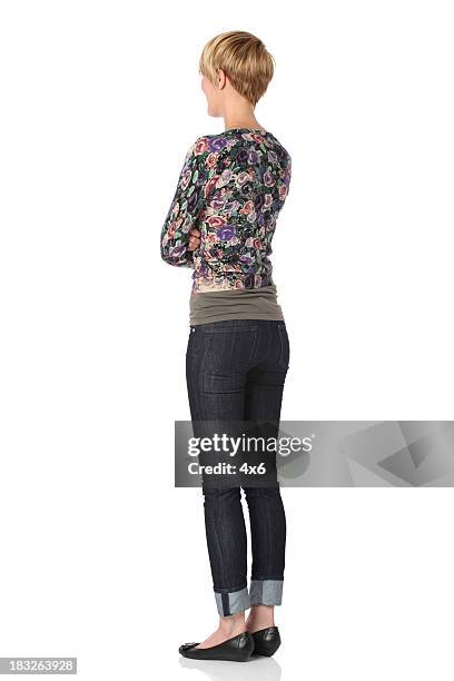 woman standing with arms crossed - jeans back stockfoto's en -beelden