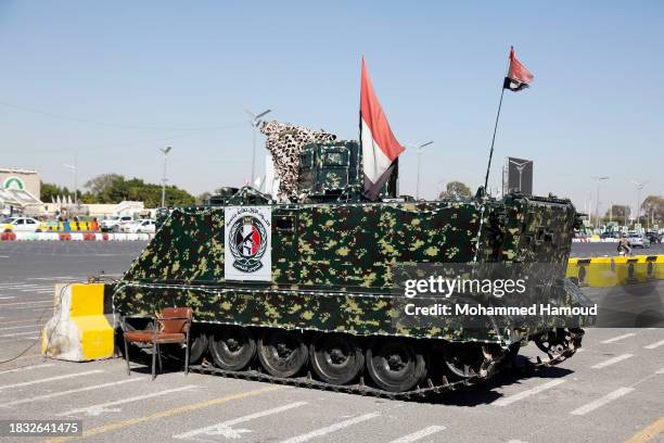 Yemenis drive next to an armored positioned for manning in Al-Sabeen square on December 05, 2023 in Sana'a, Yemen.