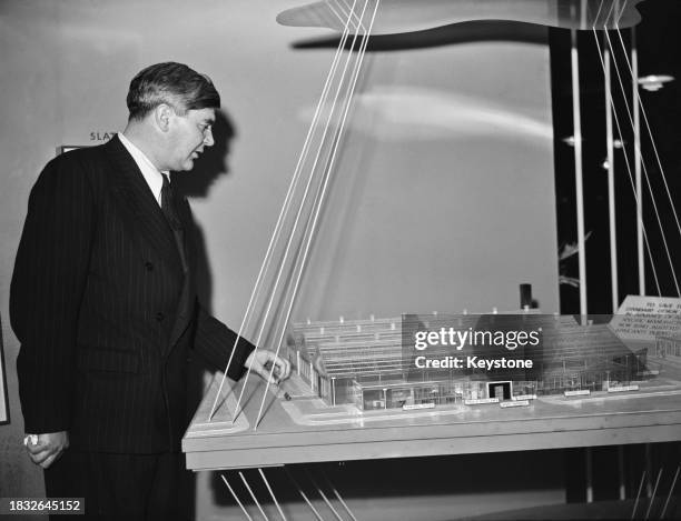 Welsh Labour Party politician Aneurin Bevan , currently Minister of Health, has a close-up view of the model of a new type of factory at the...