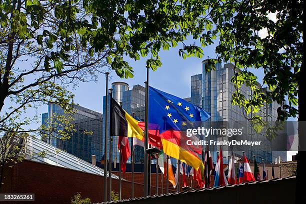 banderas frente del parlamento europeo de bruselas - eu building brussels fotografías e imágenes de stock