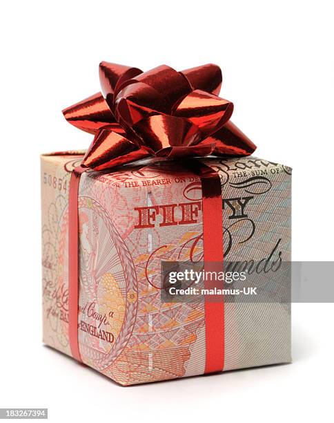 gift box wrapped in an english pound with a red bow - 50 pound notes stock pictures, royalty-free photos & images