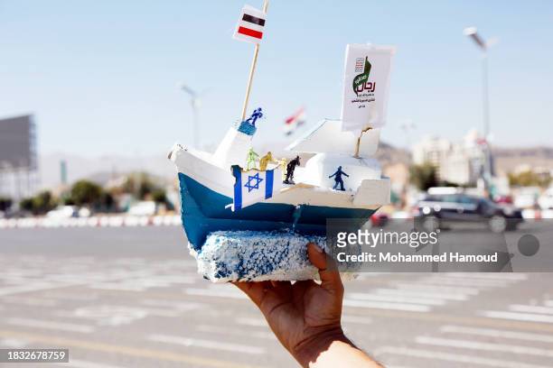 Fine artist displays a mock model of the Israeli Galaxy Leader cargo ship, carrying Palestinian flag and the Houthi movement's emblems, for sale in a...