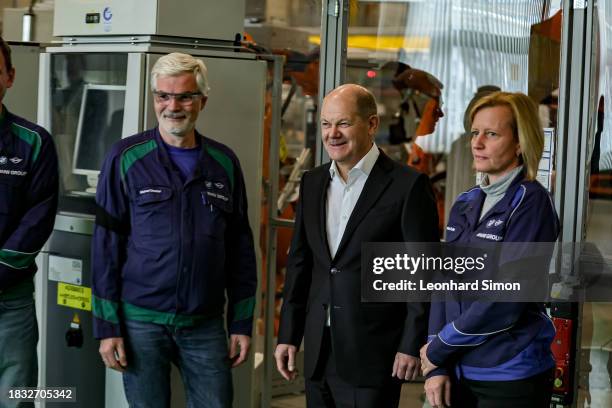 German Chancellor Olaf Scholz chats with workers during his visit to the BMW Group car factory on December 05, 2023 in Munich, Germany. His visit is...