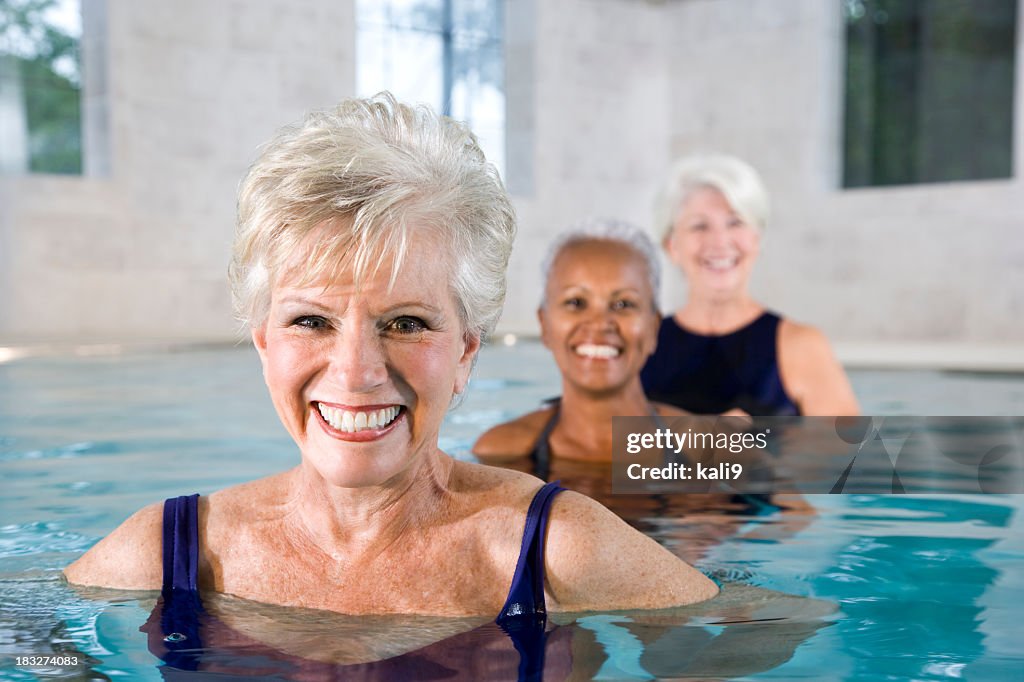 Multirracial mujeres mayores en la piscina bajo techo, gimnasio y spa