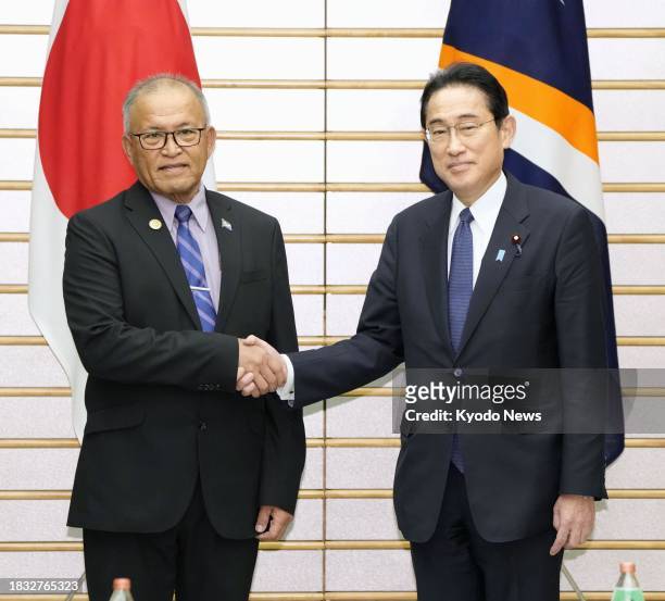 Japanese Prime Minister Fumio Kishida shakes hands with Marshall Islands President David Kabua at the premier's office in Tokyo on Dec. 8, 2023.