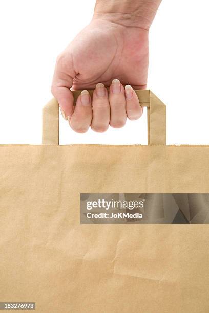 holding a paper shopping bag - kraft bag stock pictures, royalty-free photos & images