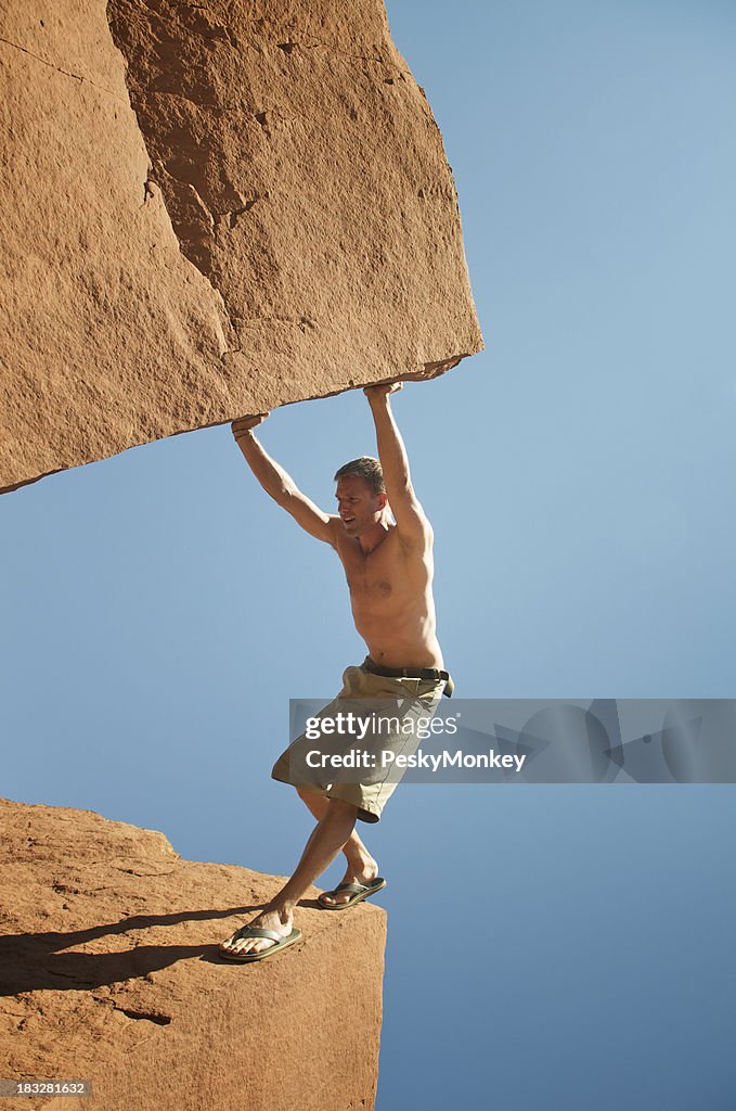 Guy in Shorts Stands Wedged Between Massive Boulders