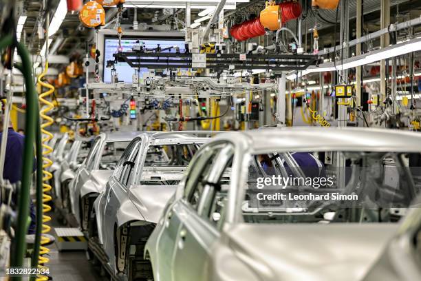 Members of BMW's manufacturing staff inspect a vehicle's finish as they work at the body shop finish during German Chancellor Olaf Scholz visits the...