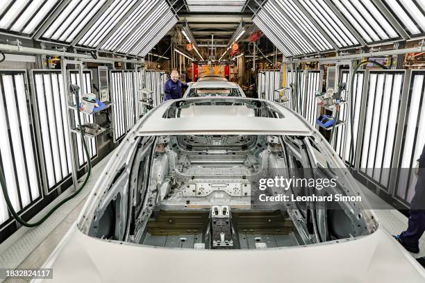 Member of BMW's manufacturing staff inspects a vehicle's finish as he works at the body shop finish during German Chancellor Olaf Scholz visits the...