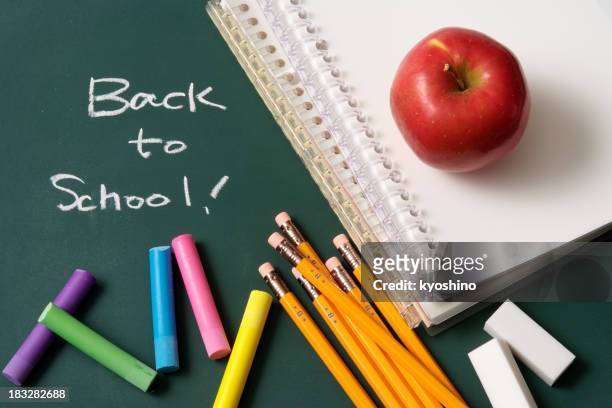 back to school written on a blackboard with school supplies - achtergrond krijtbord blauw stockfoto's en -beelden