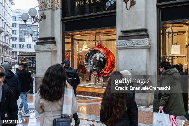 People wal past the Italian luxury fashion house Prada flagship store, whose window displays Christmas decorations, in Galleria Vittorio Emanuele II...