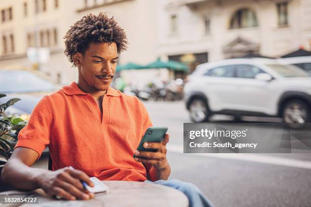 homem usando telefone inteligente - masculinidade moderna - fotografias e filmes do acervo