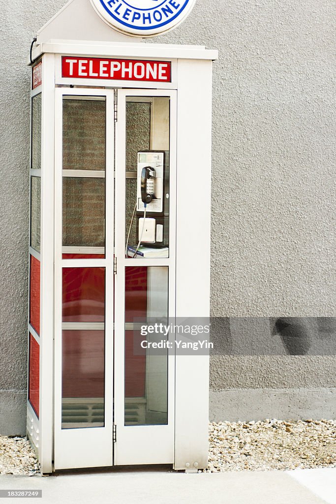 Classic Old-Fashioned American Phone Booth by Building Wall