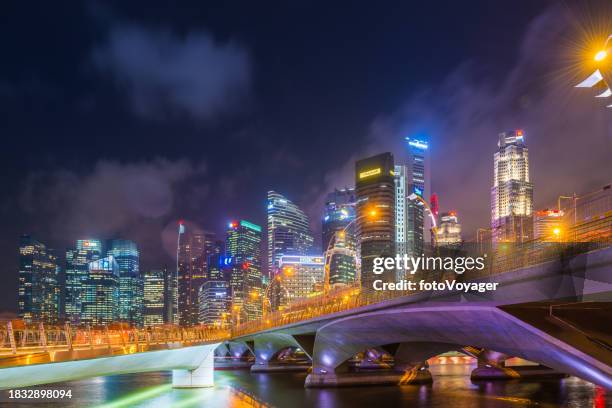 singapore skyscrapers glittering at night overlooking marina bay bridges - singapore stock pictures, royalty-free photos & images