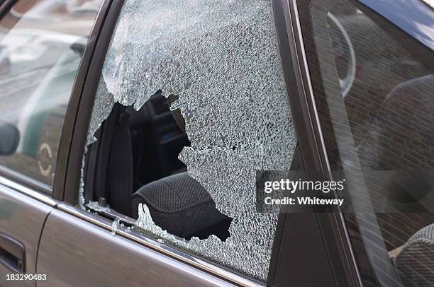 thief broken glass in car window - breaking window stockfoto's en -beelden