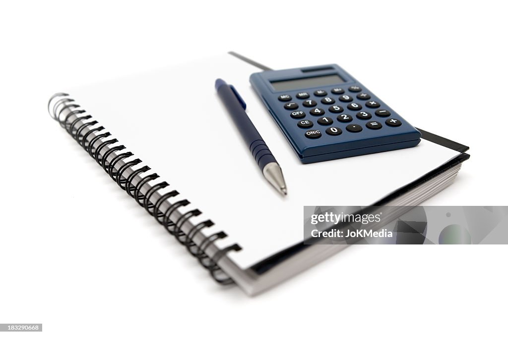 Calculator and pen on a wire bound notebook, on white
