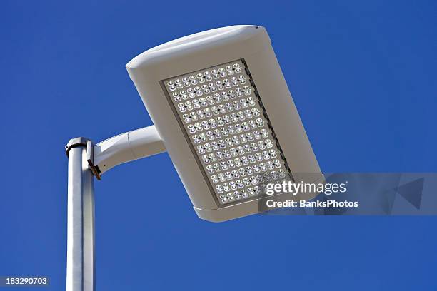 led streetlight gegen einen blauen himmel - led street lighting stock-fotos und bilder