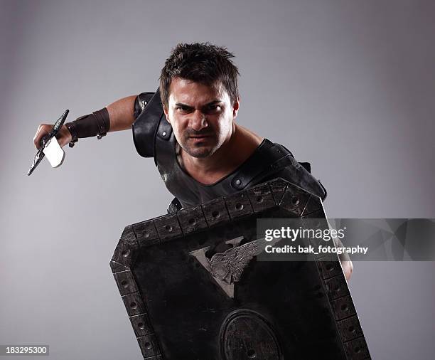 a gladiator holding an armor and a blade  - sword fight stock pictures, royalty-free photos & images