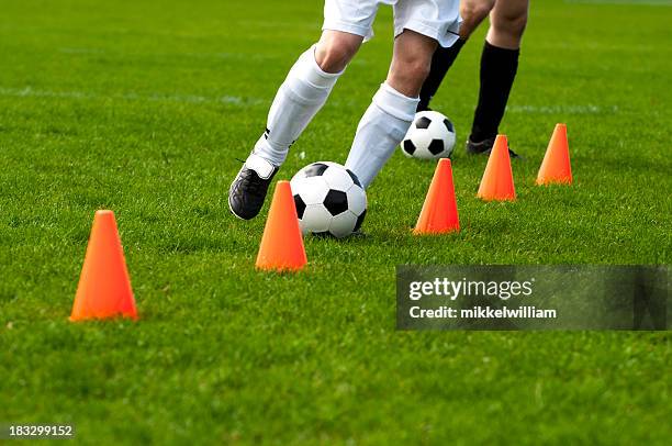 jugadores de fútbol con conos de fútbol pasado durante la sesión de capacitación - football training fotografías e imágenes de stock