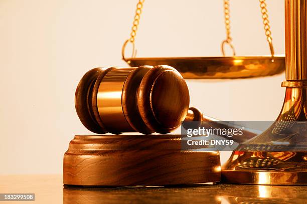 gavel and sound block at base of brass scale of justice - justice concept stock pictures, royalty-free photos & images