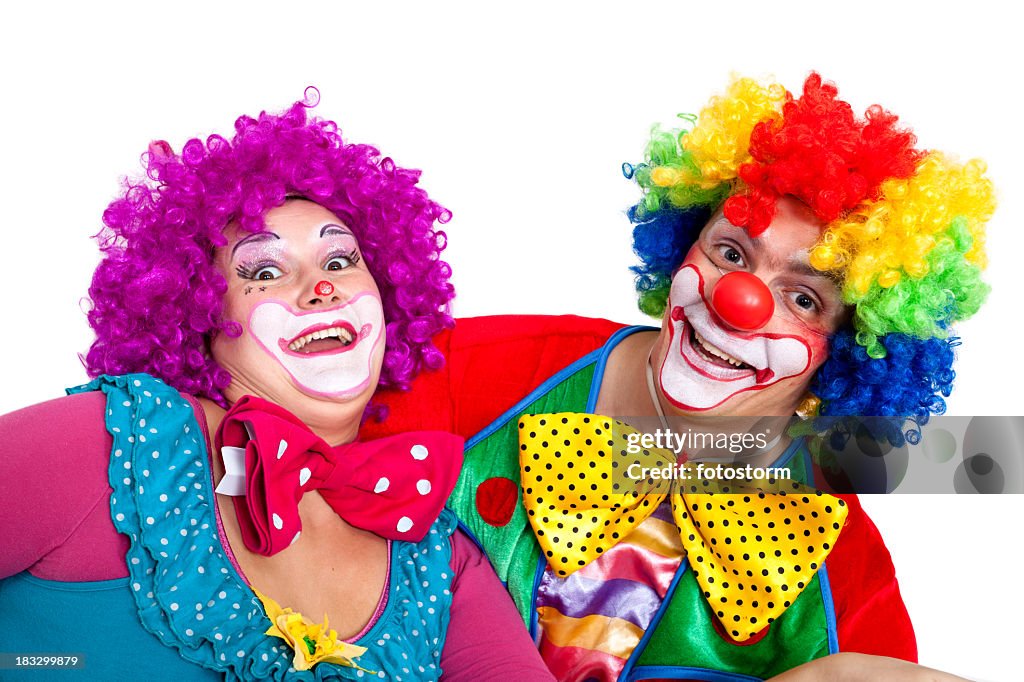 Two happy clowns making faces on white background