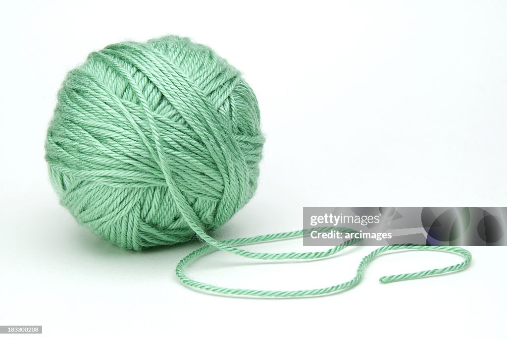 Grüne Kugel aus Garn auf weißem Hintergrund