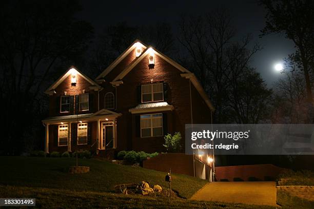 house at night with lights and moon shining - moonlight stock pictures, royalty-free photos & images