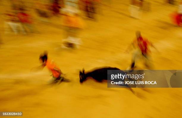Men run from a bull during the 'encierro' in the bullring during the San Roque Fair, southern Spain 16 August 2004. AFP PHOTO/ JOSÉ LUIS ROCA