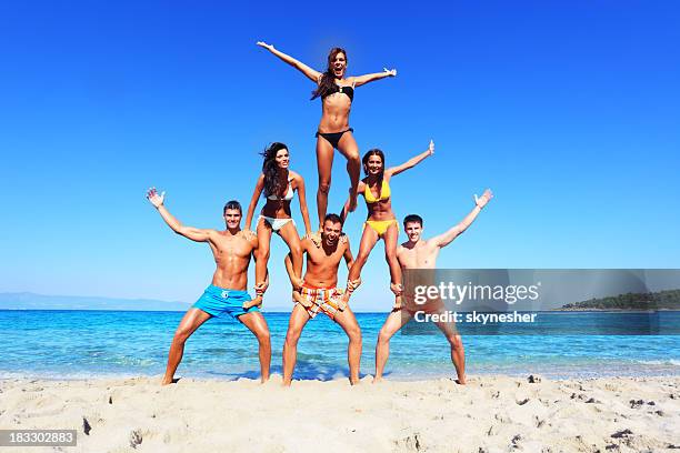 fun on the beach. - human pyramid stock pictures, royalty-free photos & images