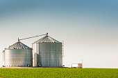 Grain Silo Bins and Truck in Farm Field Agricultural Landscape