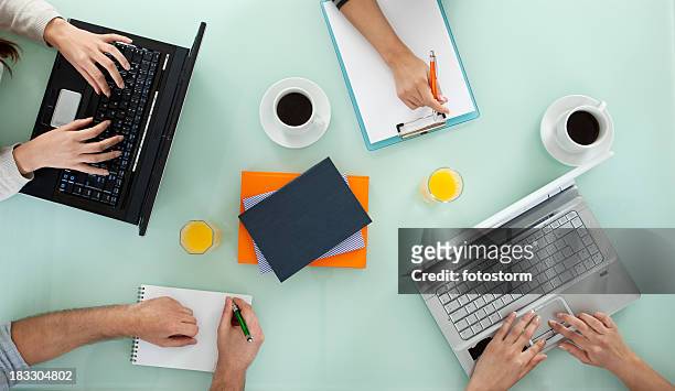 young team working on laptop computers and writing - overhead view stock pictures, royalty-free photos & images