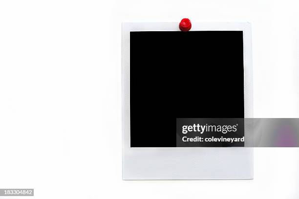 instant photo held up by a red thumbtack - picture frame stockfoto's en -beelden