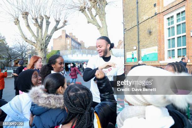 Kwajo Tweneboa interacts with children as he attends The Caring Family Foundation's "Food from the Heart" Campaign at Surrey Square Primary School...