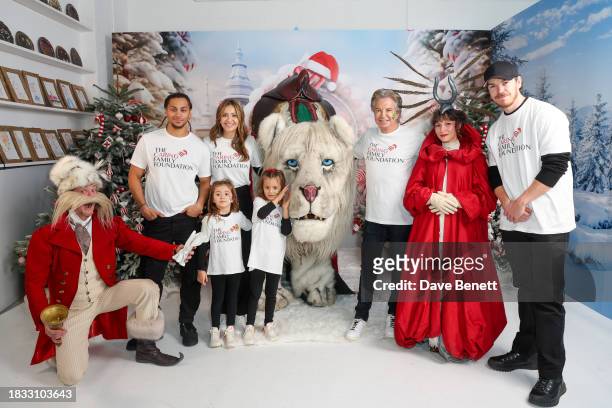 Bluey Robinson, Patricia Caring, Richard Caring and Will Poulter pose with children and people dressed up, as they attend The Caring Family...