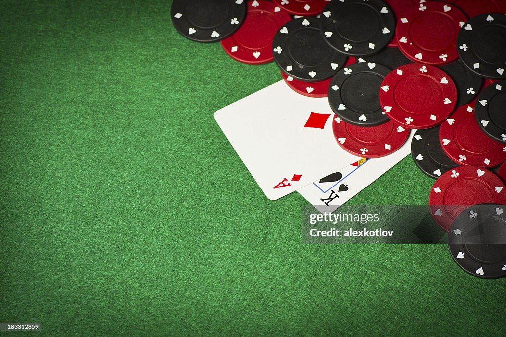 Poker table with gambling chips and two cards under them