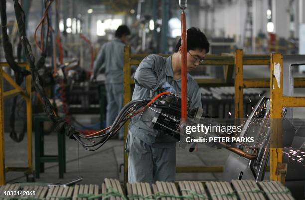 Worker spot welds doors for a Zhongxing sports utility vehicle on the production line at the Zhongxing Automobile factory in Baoding, 200 kms south...