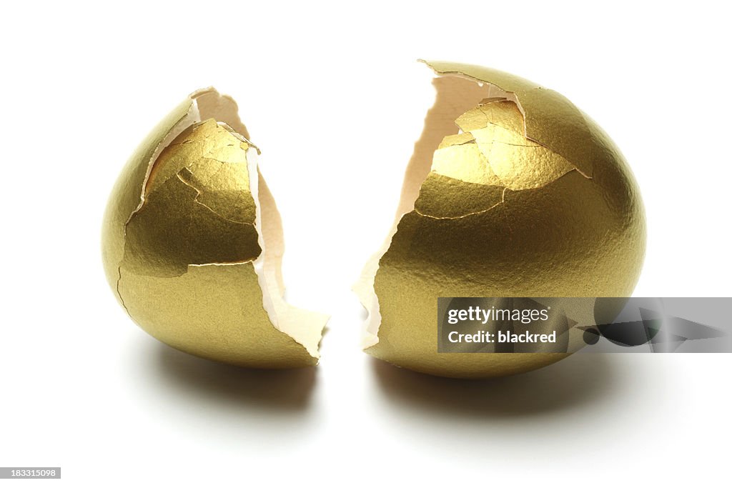 Crack Opened Gold Egg on White Background